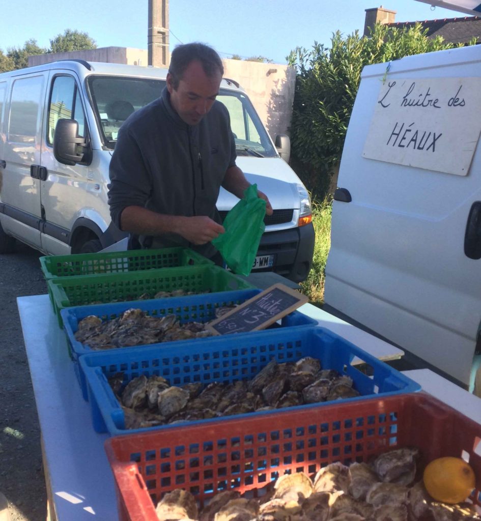 Pierre sert des huîtres sur son stand à Lézardrieux